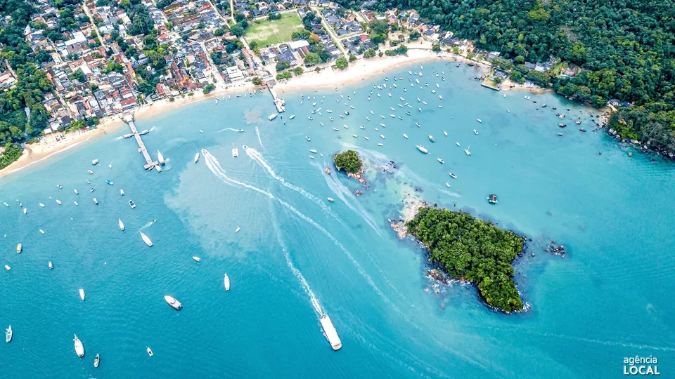 Vista aérea da Vila do Abraão, com a praia, o cais e os barcos ancorados na enseada - pousadas em Ilha Grande